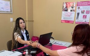 Mujer funcionaria del INE atendiendo a otra mujer