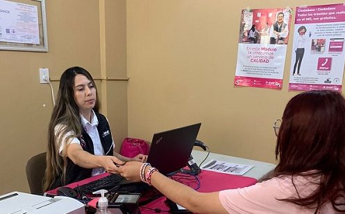 Mujer funcionaria del INE atendiendo a otra mujer