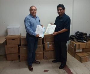Dos hombres de pie sosteniendo dos cuadernillos, posando para fotografía