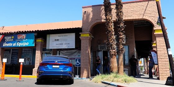 Fachada de edificio con un carro azul estacionado