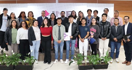 Asistentes a la presentación en escenario posando para fotografía