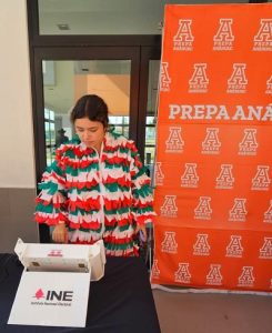 Alumna de preparatoria votando en urna electrónica del INE