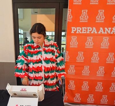 Alumna de preparatoria votando en urna electrónica del INE