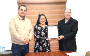 Hombre con las manos cruzadas, mujer de lentes y hombre de lentes sosteniendo hoja