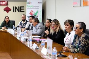 varias personas sentadas atrás de una mesa con micrófonos