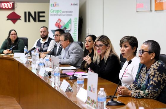 varias personas sentadas atrás de una mesa con micrófonos