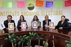 personas sentadas sosteniendo cuadernos de diferentes colores