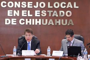 dos perspnas sentadas frente dos micrófonos color negro