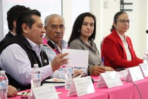 tres personas mirando a un hombre que habla