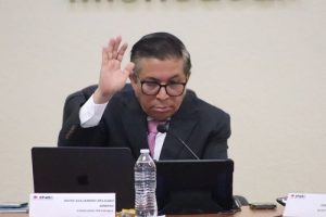 hombre sentado levantando el brazo derecho