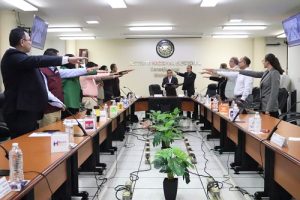 personas de pie con el brazo derecho extendido al frente