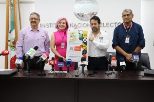 cuatro personas de pie mostrando un cartel de colores