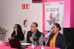 tres personas sentadas frentes a una computadora