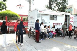 Personas haciendo fila a las afueras de Módulo de Atención Ciudadana Móvil