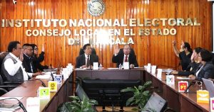 personas sentadas votando a mano alzada