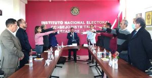 personas de pie con el brazo derecho extendido hacia enfrente