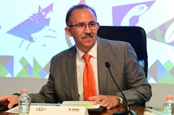 Hombre de lentes sentado frente a un micrófono color negro