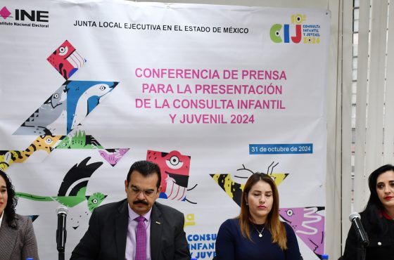 Autoridades del INE sentadas detrás de mesa, a su espalda cártel de la Consulta Infantil y Juvenil 2024