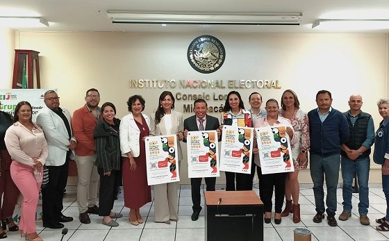 Integrantes del INE posando para fotografía con cárteles de la CIyJ