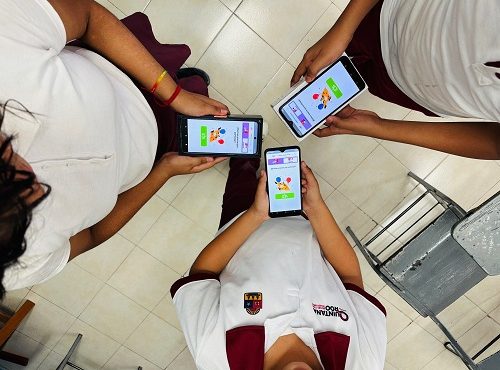 Tres dispositivos móviles sostenidos por niños