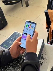 Manos de joven utilizando celular para ingresar a página de la Consulta Infantil y Juvenil 2024