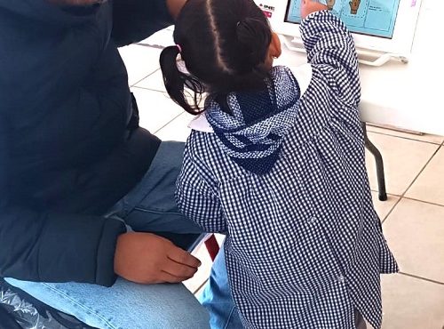 Hombre de lentes y niña utilizando dispositivo móvil