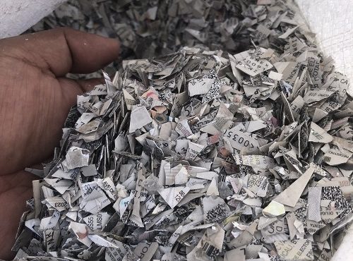 Mano moviendo credenciales para votar trituradas