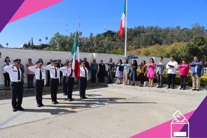 Escolta marchando con bandera nacional frente a integrantes del INE