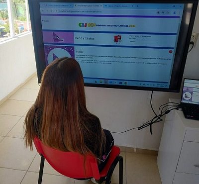 Niña frente a pantalla en portal web de la consulta
