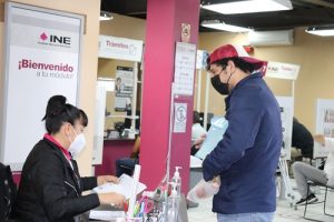 Integrante del INE auxiliando a hombre en Módulo de Atención Ciudadana