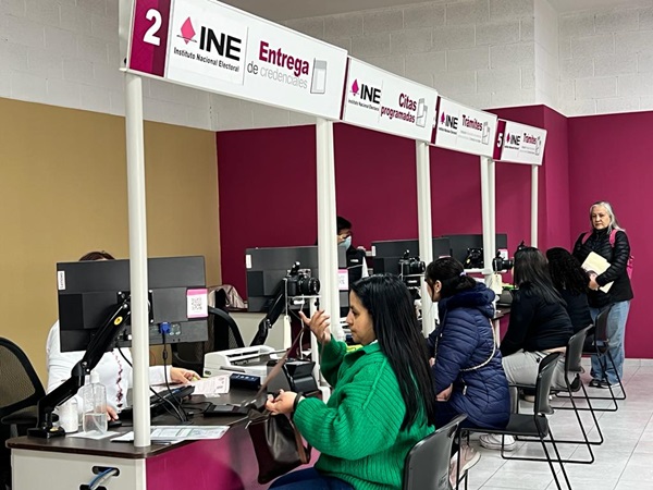 Tres personas sentadas en el Módulo de Atención del INE.