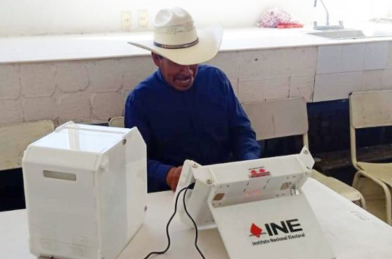 Hombre de sombrero vaquero, sentado utilizando urna electrónica