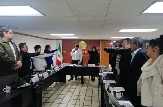 Integrantes del INE en de pie en sala de reuniones