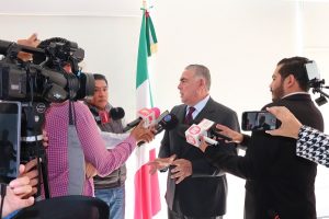 Hombre de pelo corto siendo entrevistado por reporteros