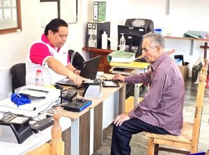 Integrante del INE ayudando a adulto mayor en Módulo de Atención Ciudadana