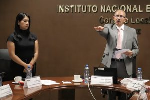 Mujer de pie junto a hombre de pie estirando brazo derecho