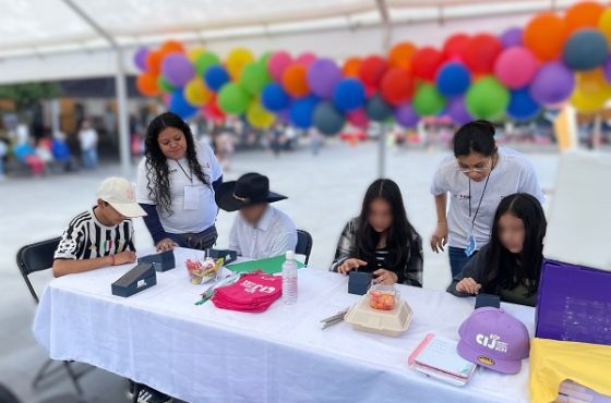 Niñas y niñas sentados detrás de mesa durante consulta