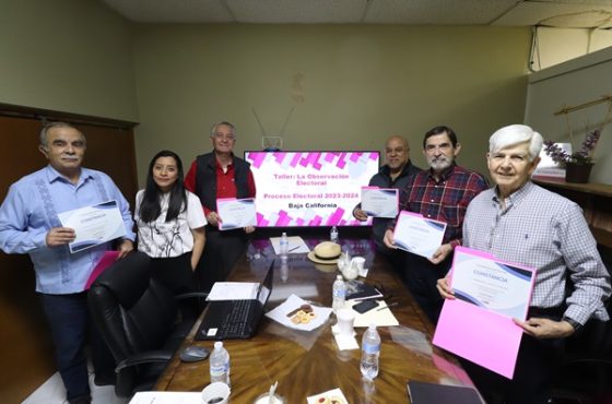 Varias personas en un salón mostrando un diploma