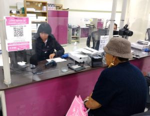 Una mujer atendiendo a otra mujer en un módulo del INE