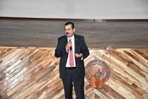 Hombre de pie, hablando con un micrófono