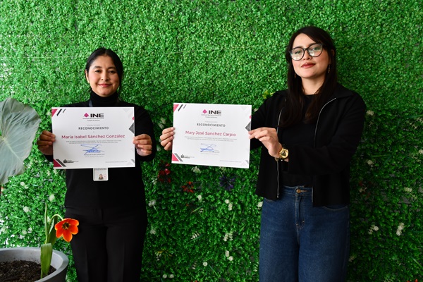 Dos mujeres sosteniendo cada una, un diploma