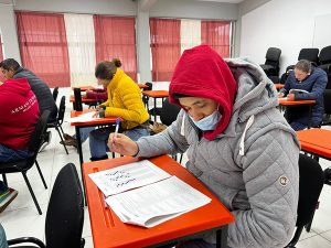 Persona con cubreboca resolviendo evaluación