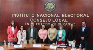 ocho personas de pie juntas para tomarse foto grupal