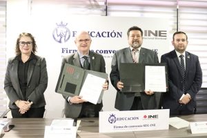 cuatro personas de pie sosteniendo un documento