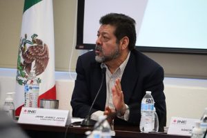 Hombre sentado hablando frente a un micrófono