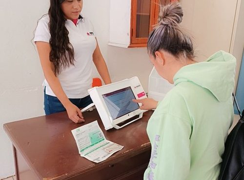 una mujer votando en la urna electrónica