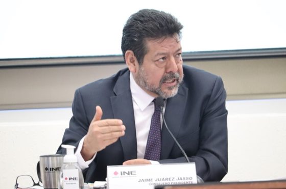 una persona sentada mirado hacia la izquierda con la mano extendida