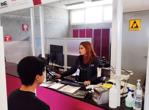 Mujer atendiendo en Módulo del INE a un hombre