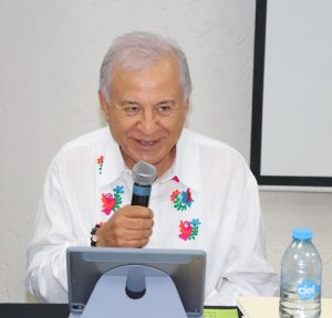 Hombre adulto mayor hablando con un micrófono