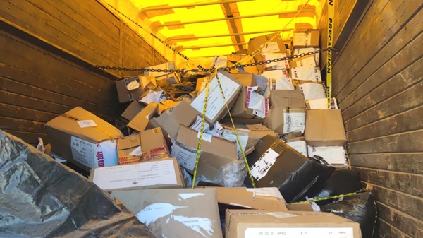 Parte trasera de un camión con lona amarilla y muchas cajas